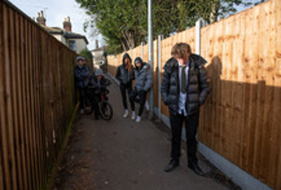 Teenagers standing in an alleyway.