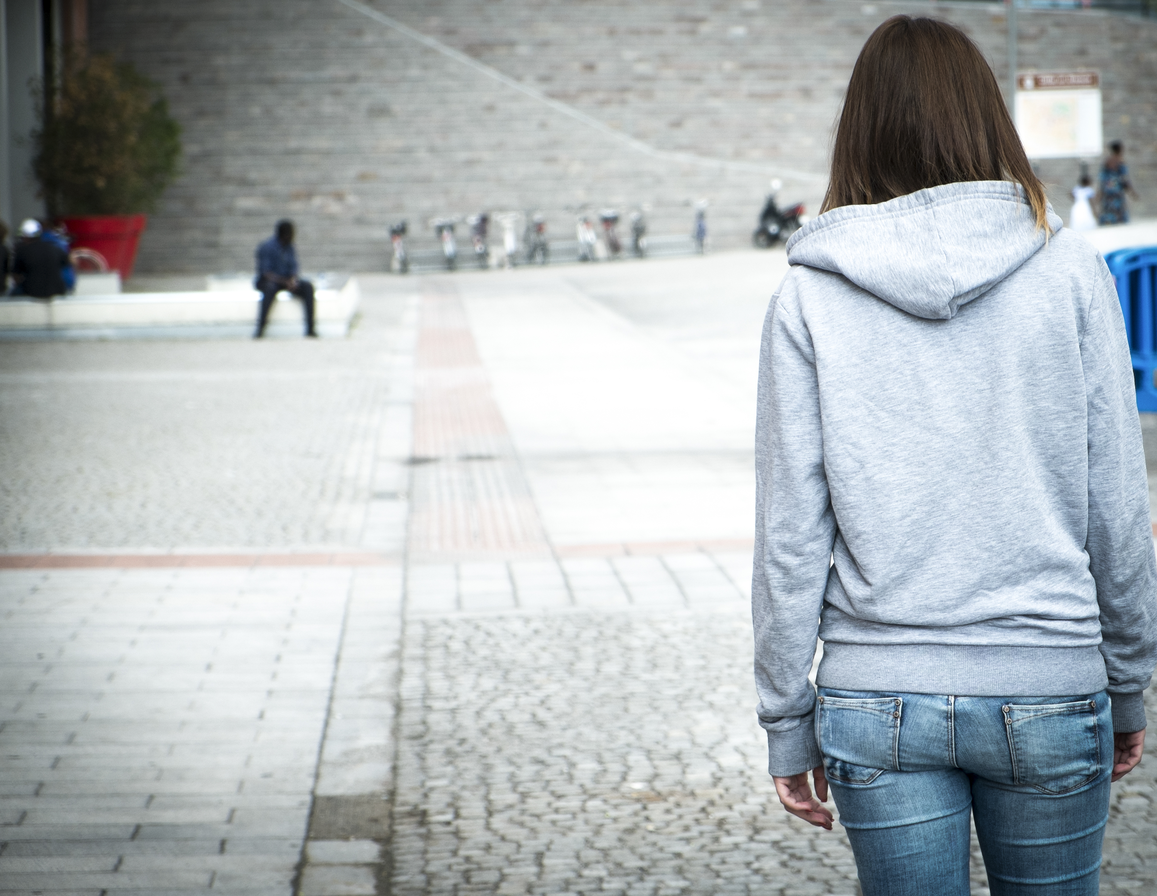 Teenage girl walking alone in a plaza