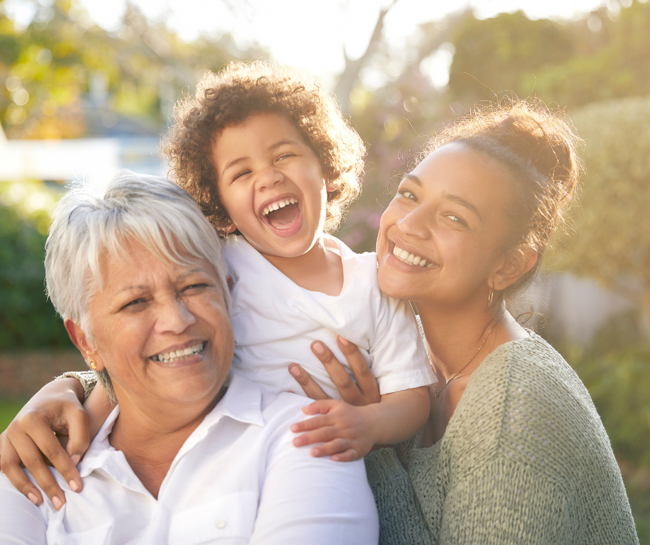 Happy child being held by his mother and grandmother