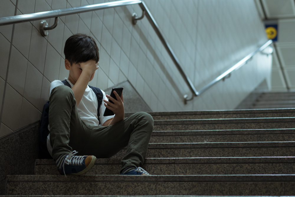 Boy sitting on public stairs